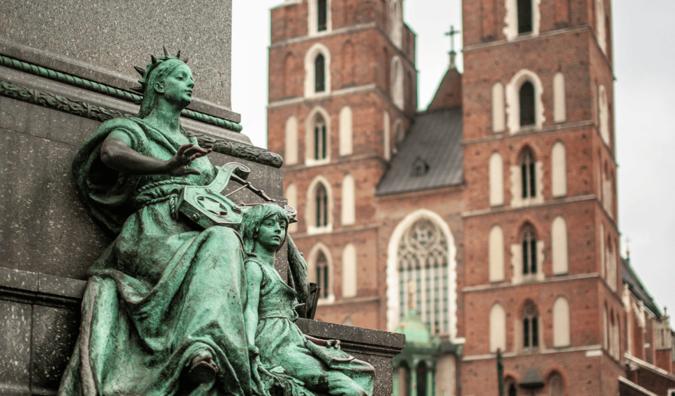 Statue and Mariacki Church in Kraków