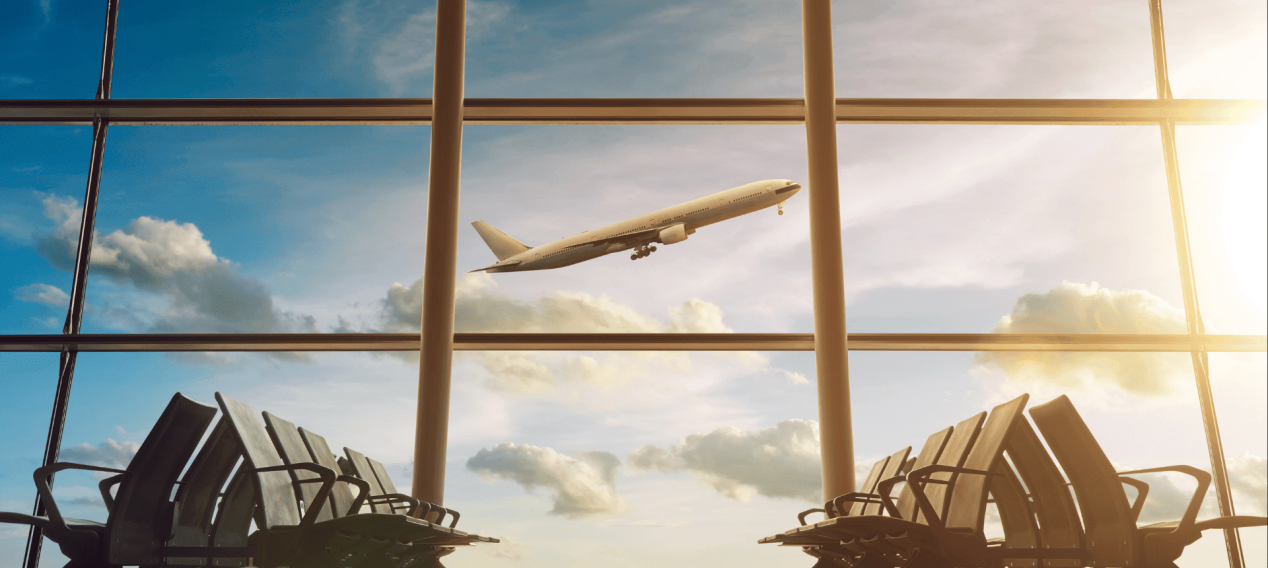 Airport lounge with airplane in the background/ jamestoeheart / Getty Images